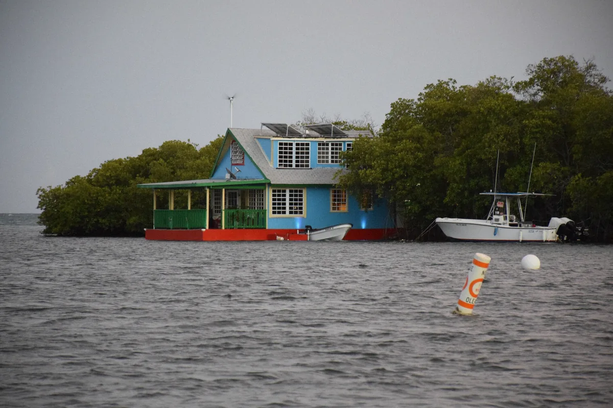 Night tour boat passing the stilt houses over the water in La Parguera, Lajas, Puerto Rico